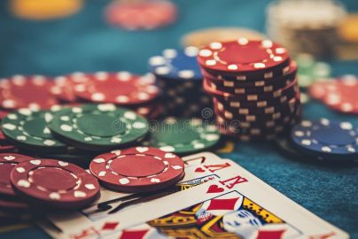 Close-up of playing cards and poker chips on a green felt surface, symbolizing gambling activities.