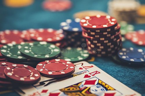 Close-up of playing cards and poker chips on a green felt surface, symbolizing gambling activities.